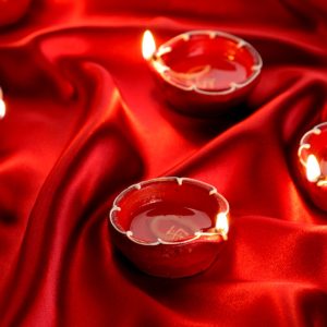2 clear glass candle holders on red textile