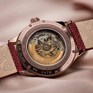 A close up of a watch on a bed