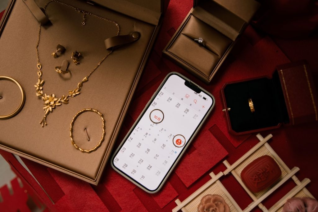 Gold jewelry and rings displayed with a smartphone.