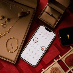 Gold jewelry and rings displayed with a smartphone.