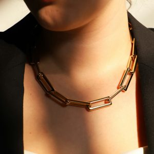 A woman wears a chunky gold chain necklace.