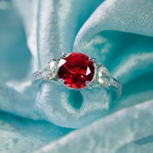 A ruby and diamond ring on blue silk