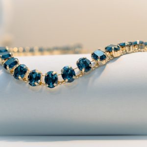 A delicate gold bracelet with dark blue gems.