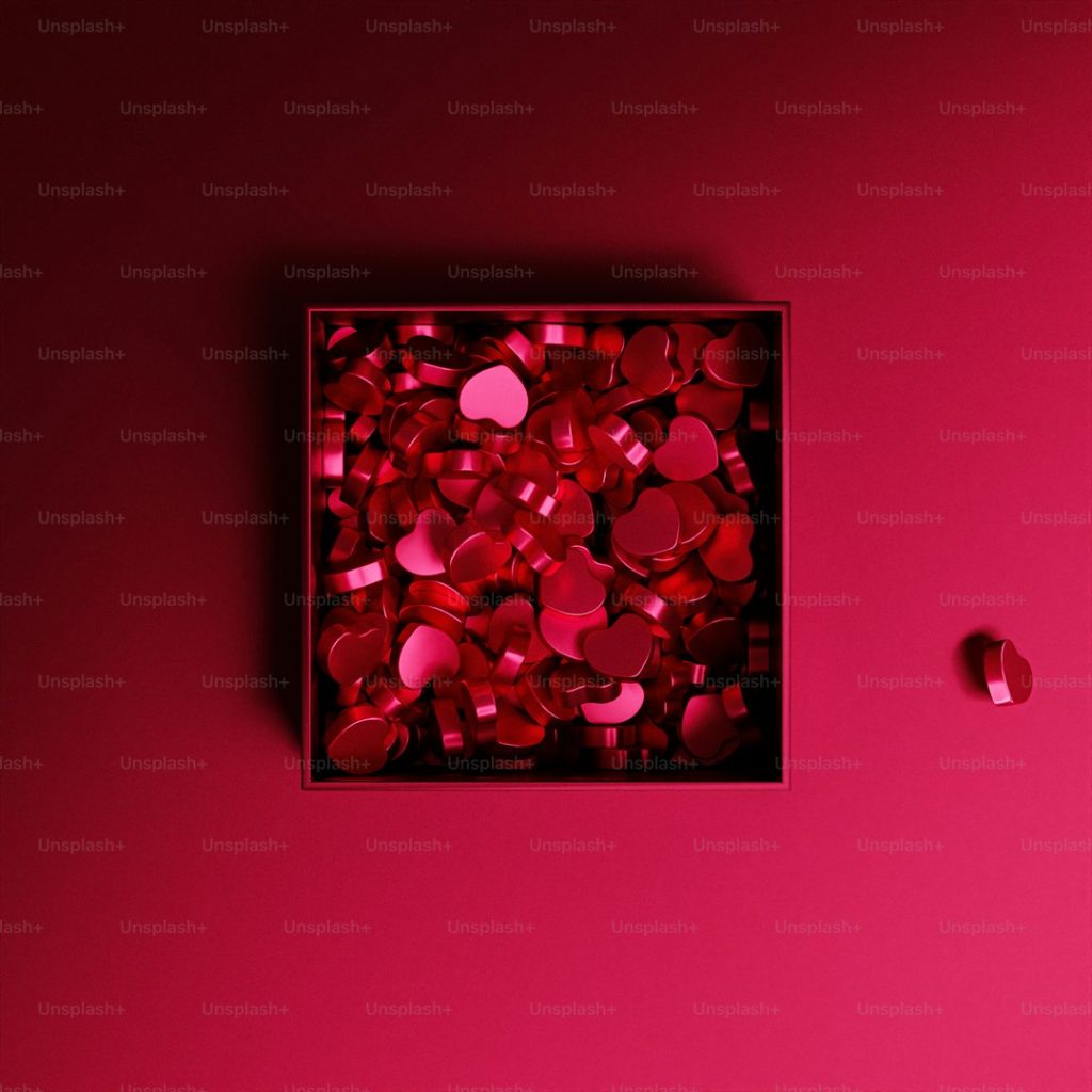a box of red hearts on a pink background