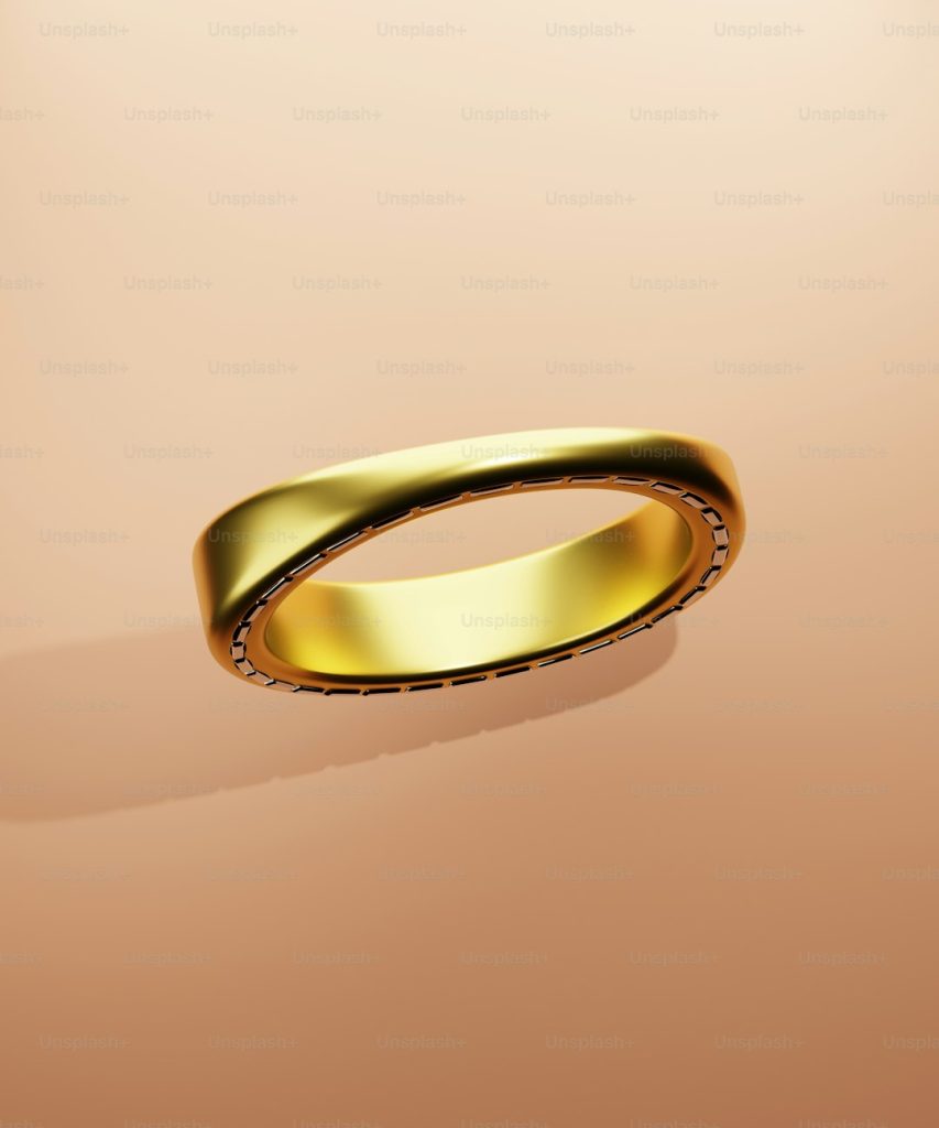a gold ring on a pink background